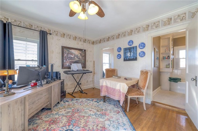 home office with crown molding, plenty of natural light, and light hardwood / wood-style floors