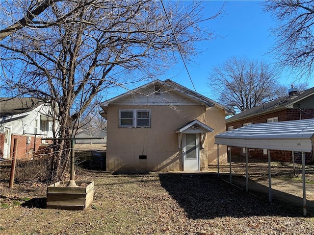 back of property featuring an outbuilding and a carport