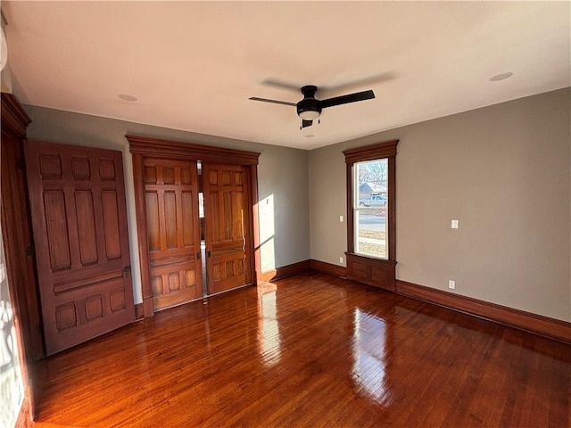 unfurnished bedroom featuring dark wood-type flooring and ceiling fan