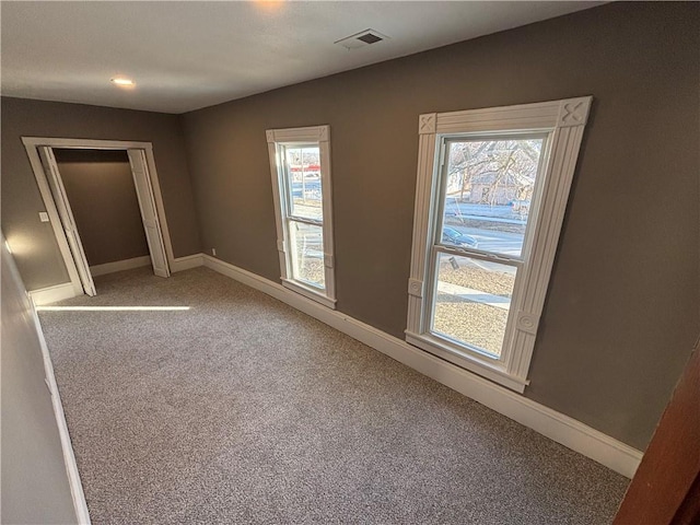 unfurnished bedroom featuring a closet, carpet flooring, and multiple windows