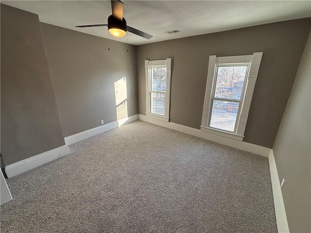 empty room with ceiling fan and carpet