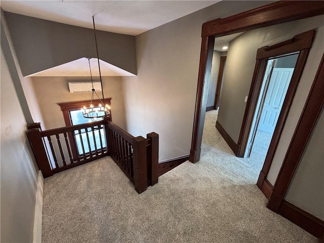 stairs with a notable chandelier and carpet floors