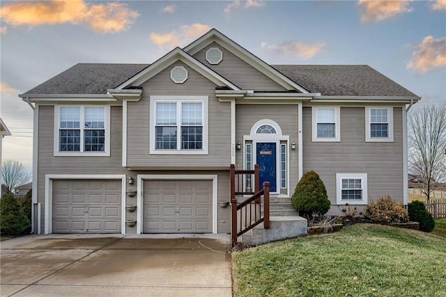 bi-level home featuring a garage and a yard