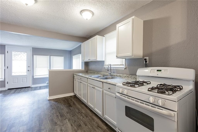 kitchen featuring a wealth of natural light, sink, white cabinetry, and white range with gas cooktop