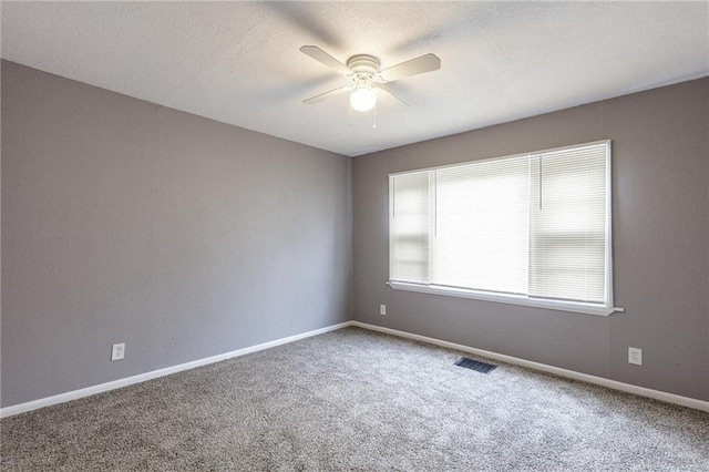 empty room featuring ceiling fan and carpet