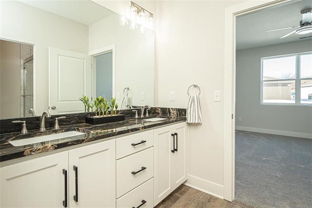 bathroom with vanity, ceiling fan, and walk in shower