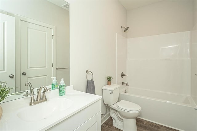 full bathroom with vanity, washtub / shower combination, toilet, and wood-type flooring