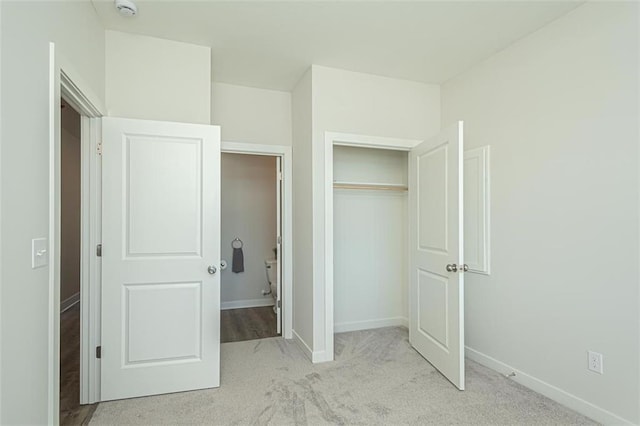 unfurnished bedroom with light carpet and a closet