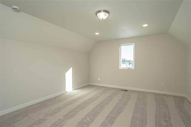 additional living space with light colored carpet and lofted ceiling