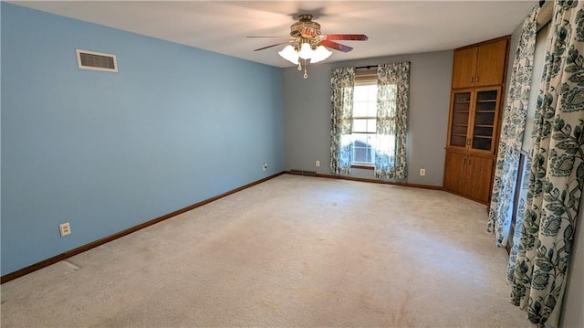 empty room featuring light colored carpet and ceiling fan