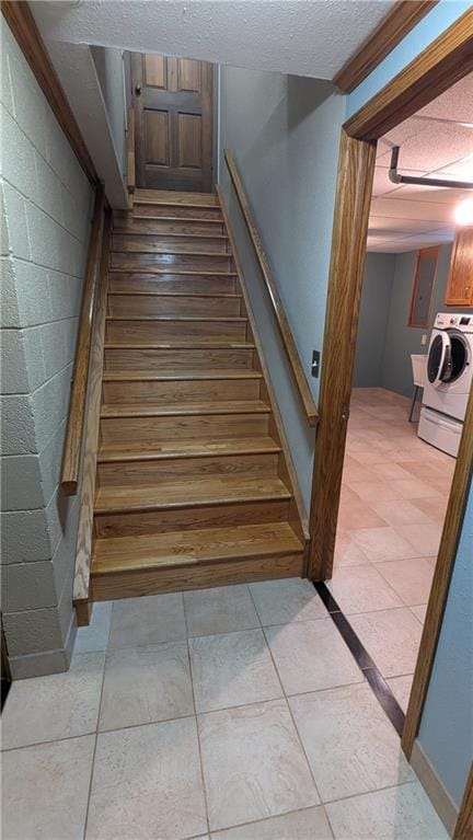 stairs with crown molding and washer / clothes dryer