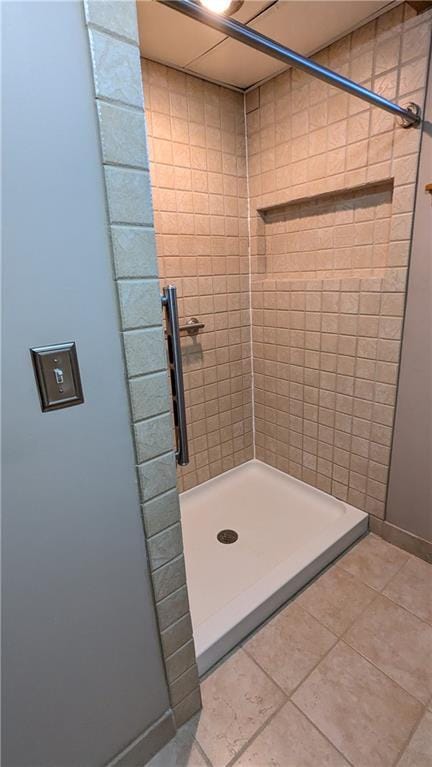 bathroom with tile patterned floors and tiled shower