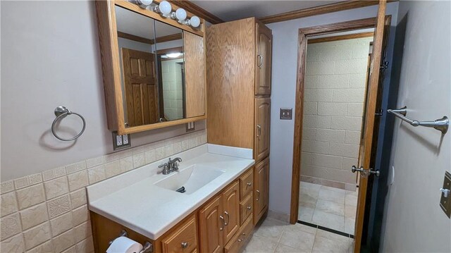 bathroom with vanity, tile walls, and crown molding