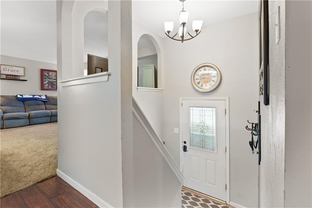 foyer entrance featuring dark hardwood / wood-style floors and a notable chandelier