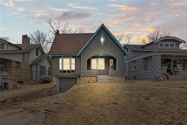 view of front of home with a garage and a lawn