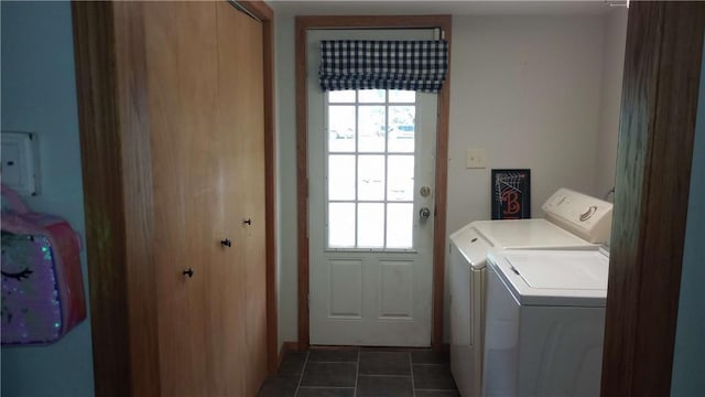 laundry area featuring a healthy amount of sunlight, dark tile patterned flooring, and washer and dryer