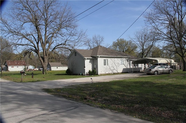 view of side of home with a lawn, driveway, and a carport