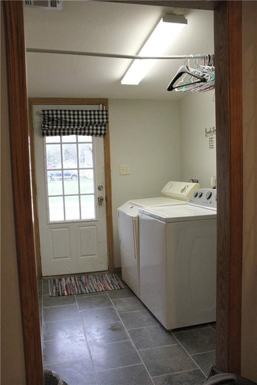 clothes washing area featuring washing machine and clothes dryer, laundry area, and visible vents