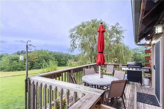 wooden terrace featuring area for grilling and a yard