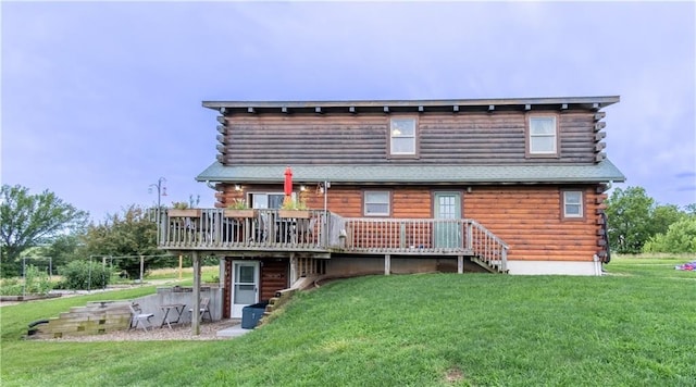 back of property featuring a wooden deck and a lawn