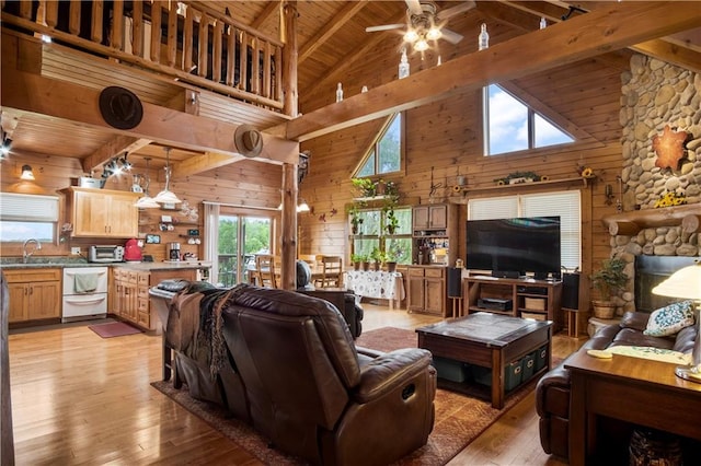 living room with sink, wood walls, wooden ceiling, beamed ceiling, and light wood-type flooring