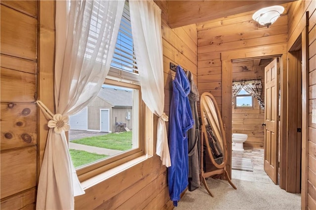 bathroom featuring wooden walls and toilet