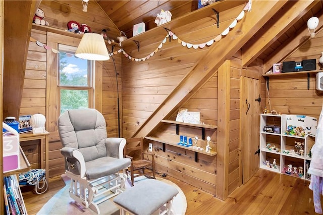 sitting room featuring wood ceiling, wood-type flooring, wooden walls, and vaulted ceiling