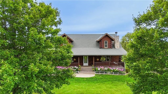 log home with a chimney, a porch, log exterior, and a front lawn