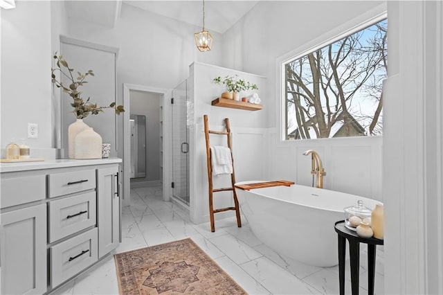 full bathroom featuring a decorative wall, marble finish floor, a soaking tub, wainscoting, and a shower stall