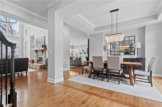 dining space featuring a healthy amount of sunlight, crown molding, a chandelier, and wood finished floors