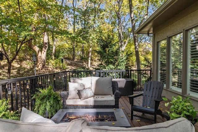 wooden terrace featuring an outdoor living space with a fire pit