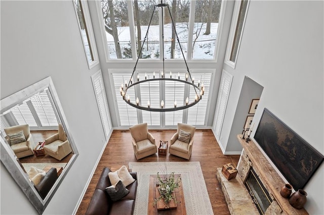 sunken living room featuring a high ceiling, wood finished floors, and baseboards