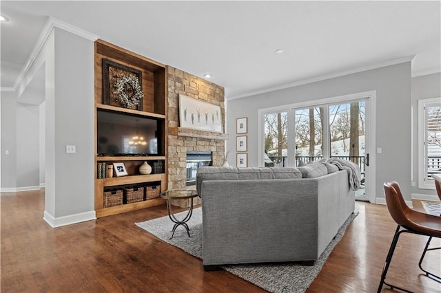 living area with ornamental molding, dark wood-type flooring, and a wealth of natural light