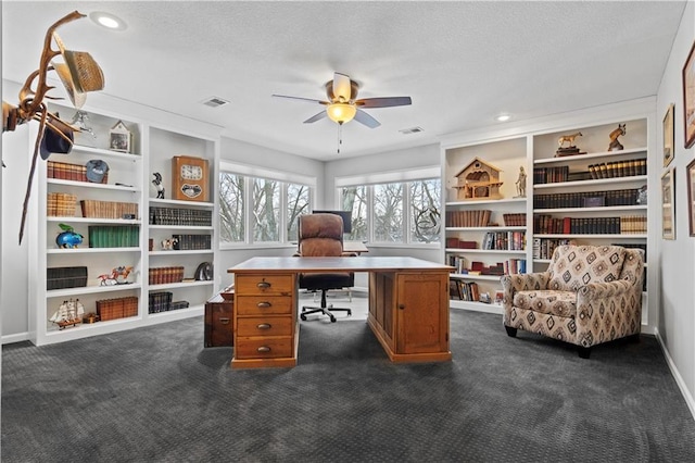 office space with dark colored carpet, visible vents, ceiling fan, and a textured ceiling