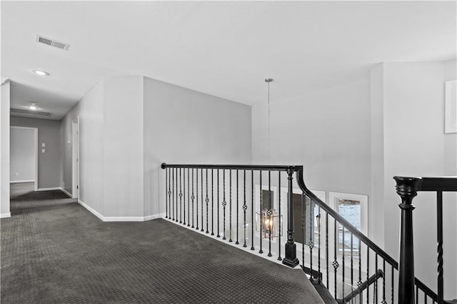 corridor featuring carpet, an upstairs landing, visible vents, and baseboards