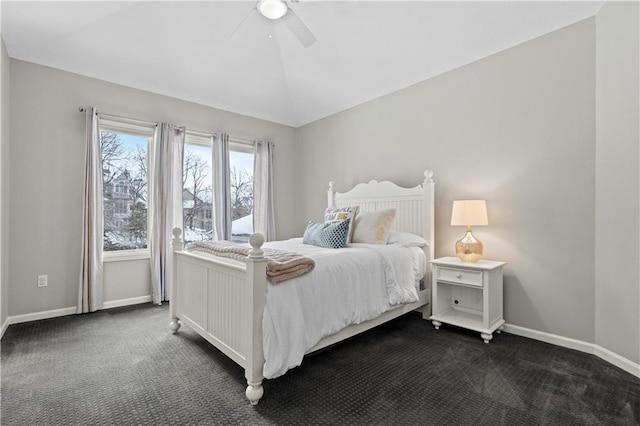 bedroom with vaulted ceiling, dark carpet, a ceiling fan, and baseboards