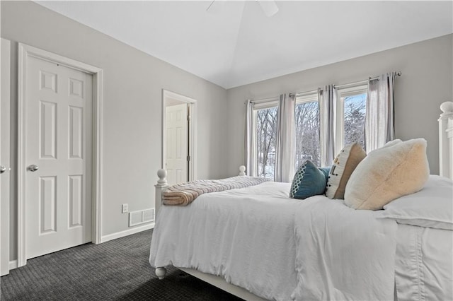 bedroom featuring visible vents, dark carpet, a ceiling fan, vaulted ceiling, and baseboards