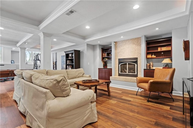 living room featuring recessed lighting, a large fireplace, wood finished floors, visible vents, and ornate columns