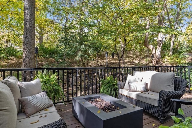 wooden terrace with an outdoor living space with a fire pit