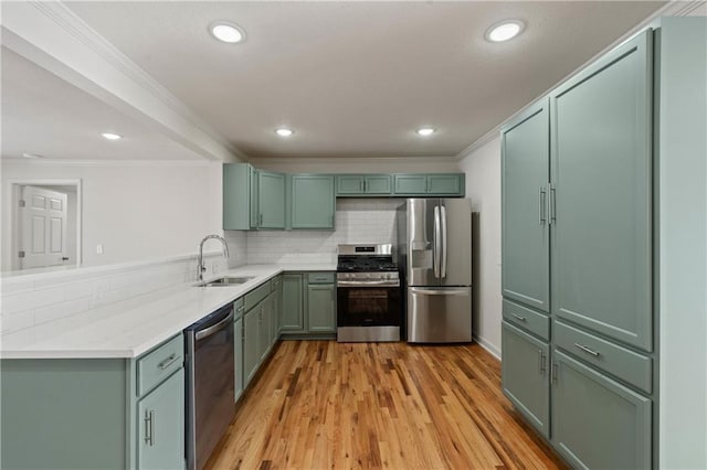 kitchen with sink, crown molding, light wood-type flooring, appliances with stainless steel finishes, and backsplash