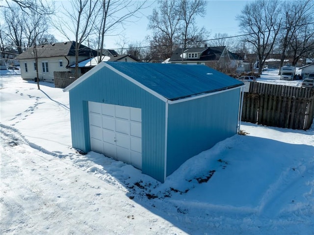 snow covered structure with a garage