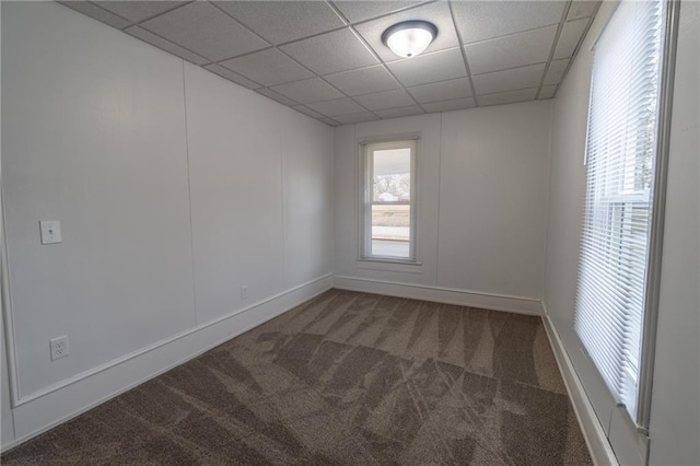 spare room with carpet floors and a drop ceiling