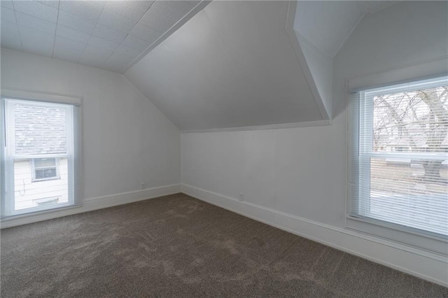 bonus room featuring vaulted ceiling and dark carpet