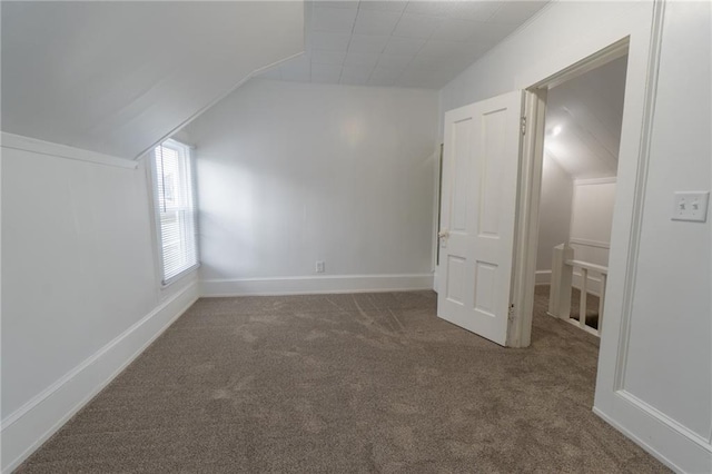 bonus room featuring dark colored carpet and lofted ceiling