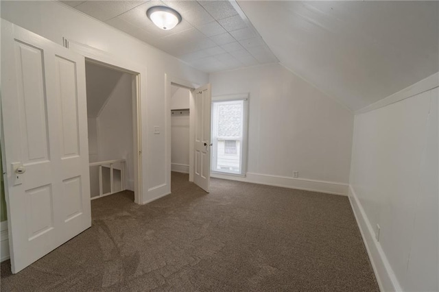 bonus room with vaulted ceiling and dark carpet