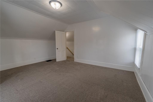 additional living space with lofted ceiling and carpet flooring