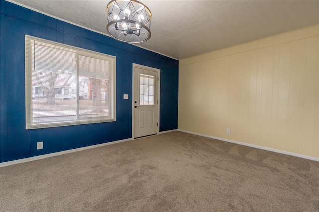 carpeted entryway featuring a chandelier