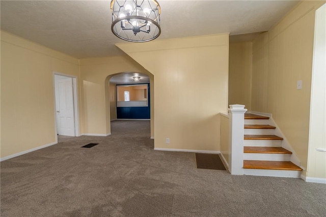 carpeted empty room with a chandelier