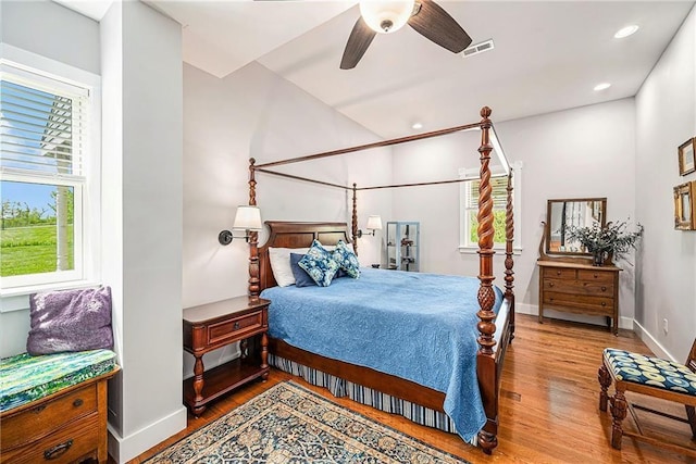 bedroom featuring ceiling fan, wood-type flooring, and multiple windows