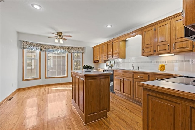 kitchen with sink, light hardwood / wood-style floors, a center island, and dishwasher